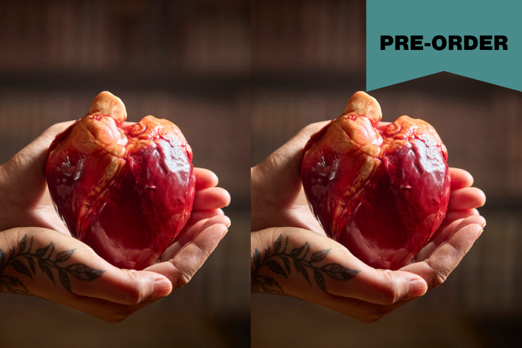 A split-screen lifestyle image showing a person's tattooed hands holding a realistic chocolate red and orange anatomical heart. The background is dark and blurred, and a gold 'PRE-ORDER' banner is in the top right corner.