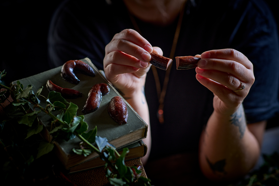 Tattoed hands hold chocolate slug