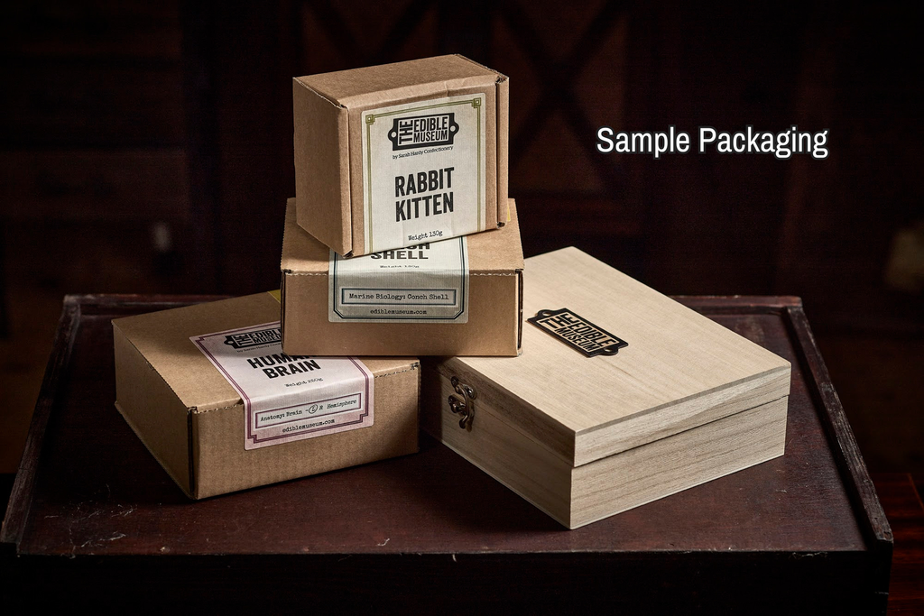 Wooden and cardboard boxes with labels on a dark background for the Edible Museum Chocolate Gift Store 